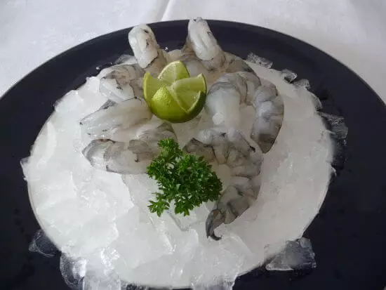 rohe Garnelen auf Eis mit Limette und Petersilie