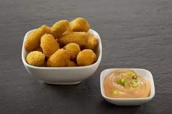 Schale mit Kartoffelkroketten und Dip auf dunklem Untergrund