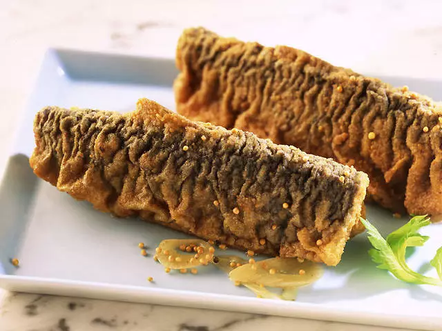 zwei gebratene Heringsfilets mit Senfkörnern auf Teller