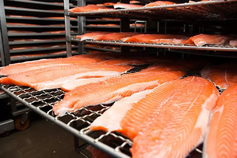 frische Lachsfilets auf Metallgittern gestapelt