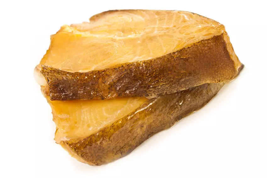 zwei Stücke geräucherter Kabeljau mit Haut auf Weiß