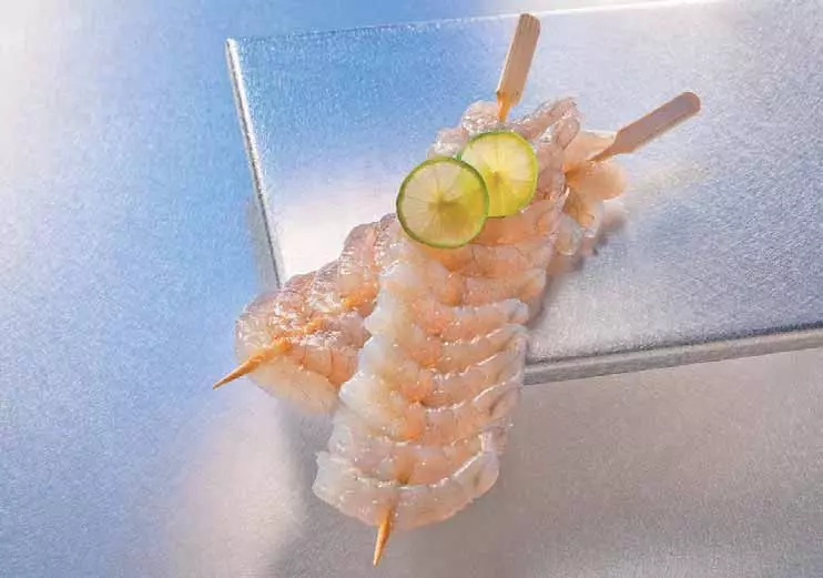rohe Garnelen auf Spießen mit Limettenscheiben
