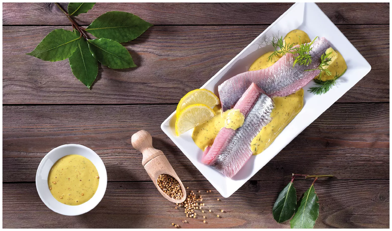Matjesfilet mit Senfsauce, Zitrone und Kräutern auf Teller